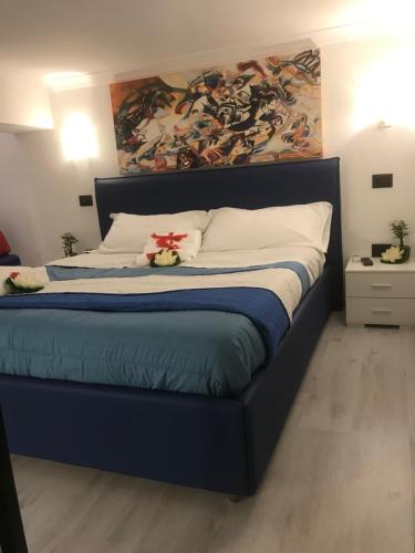 a bedroom with a large bed with a painting on the wall at La Suite sul Mare in Crotone