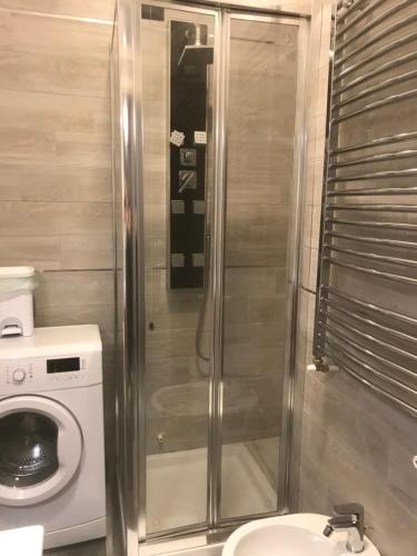 a bathroom with a shower and a washing machine at La Suite sul Mare in Crotone