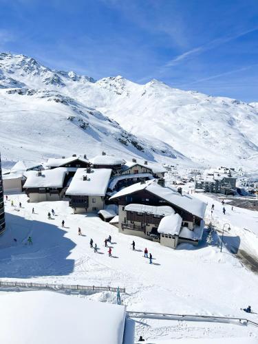 a group of people skiing down a snow covered mountain at Hôtel Club mmv Les Arolles **** in Val Thorens
