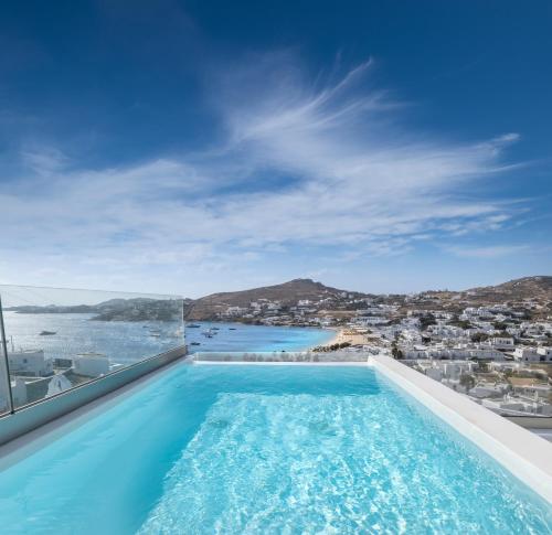 a swimming pool with a view of the ocean at Deliades Hotel in Ornos