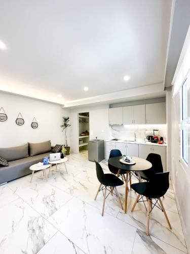 Il comprend une cuisine et un salon avec une table et des chaises. dans l'établissement Sol Apartments Corfu by Estia, à Corfou