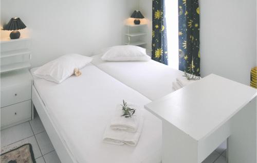 a white bedroom with two beds and a table at Soleiliosonne Haus Zeus in Ermioni