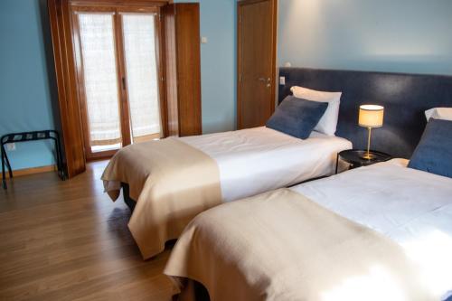 duas camas num quarto de hotel com paredes azuis em Quinta da Eira Douro Valley em Fermentões