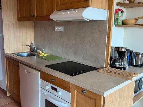 Il comprend une cuisine équipée d'une cuisinière. four supérieur à côté d'un évier dans l'établissement Studio cosy avec balcon, proche télécabine et navettes, Praloup 1500 - FR-1-165A-48, à Uvernet