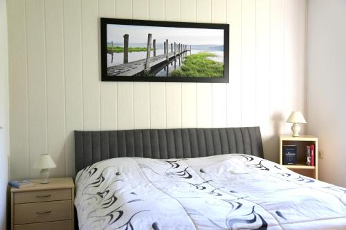 1 dormitorio con 1 cama con una foto en la pared en Bungalow mit Pool, en Pruchten