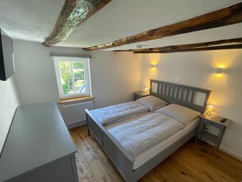 a bedroom with a bed and a table in it at Gästeappartements Mechels in Wilnsdorf