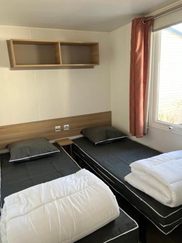 维亚斯Mobilhome Vias plage dans Camping的带窗户的房间里有两张双层床