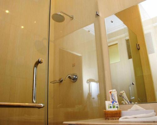 y baño con ducha y puerta de cristal. en Peacock Beach Resort and Spa, en Hambantota