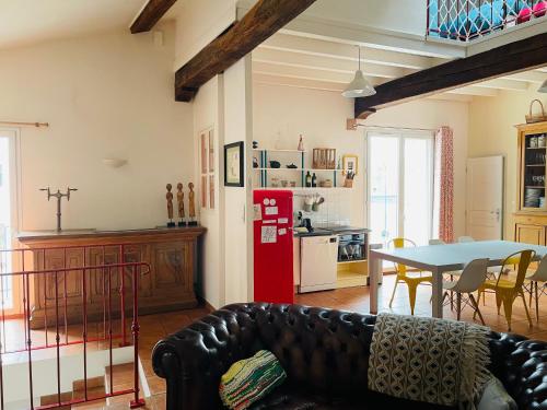 - un salon avec une table et un réfrigérateur rouge dans l'établissement Belle maison de ville en bord de Saône, à Saint-Laurent-sur-Saône