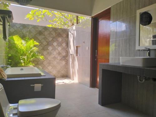 a bathroom with a toilet and a sink at Villa Jeruk in Selong Belanak