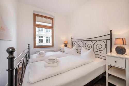アールベックにあるHaus Meerblick 03の白いベッドルーム(白いシーツと窓付きのベッド付)