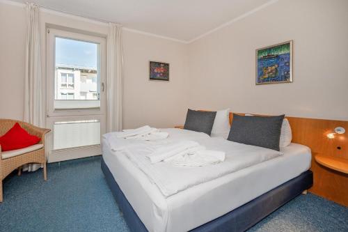 ヘリングスドルフにあるForum Marinar 25の窓付きの客室の白いベッド1台