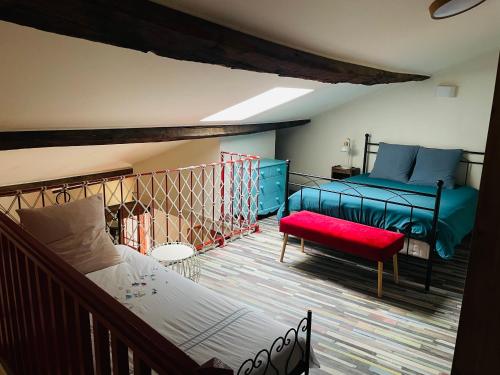 - une chambre avec deux lits et un banc rouge dans l'établissement Belle maison de ville en bord de Saône, à Saint-Laurent-sur-Saône