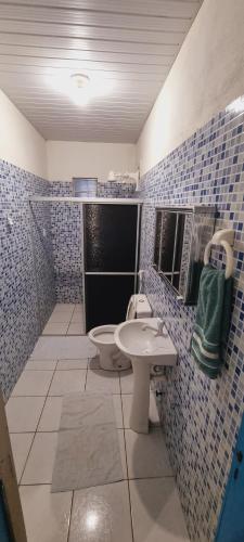 uma casa de banho em azulejos azuis com um WC e um lavatório em Casa do Galego no Residência Família em Canoa Quebrada