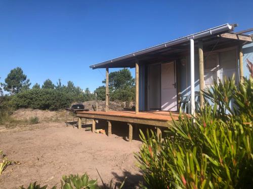 una casa con una terraza y una parrilla en ella en Fynbos Tiny Home - Off Grid, Surrounded by Nature en Plettenberg Bay