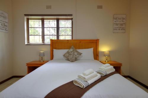 ein Schlafzimmer mit einem großen Bett mit Handtüchern darauf in der Unterkunft Eagles Nest Guesthouse in Eshowe