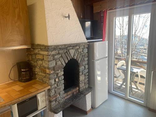 un four en pierre dans une cuisine avec une porte coulissante en verre dans l'établissement Le p'tit coin montagne 2, à Bonneval-sur-Arc