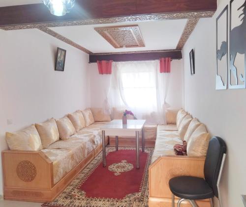 a living room with a couch and a table at Havre de Paix chez Lamine in El Harhoura