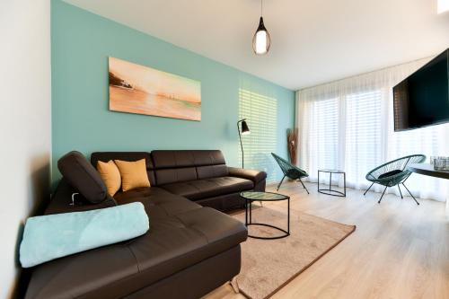 a living room with a brown couch and a table at CROWONDER Apartments & Rooms OAZA with heated Swimming Pool and Sauna in Turanj