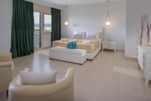 a bedroom with a bed and a couch and a chair at Villa Melissa by Estia in Hersonissos