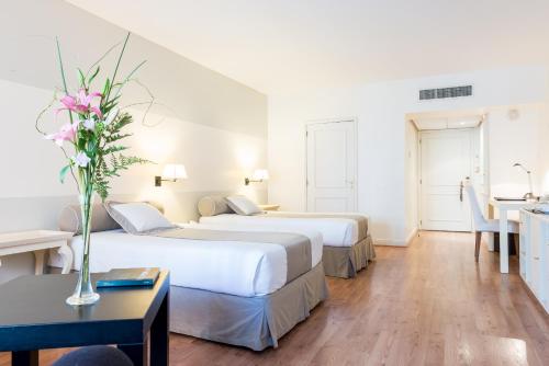 a hotel room with two beds and a table at Loi Suites Recoleta Hotel in Buenos Aires