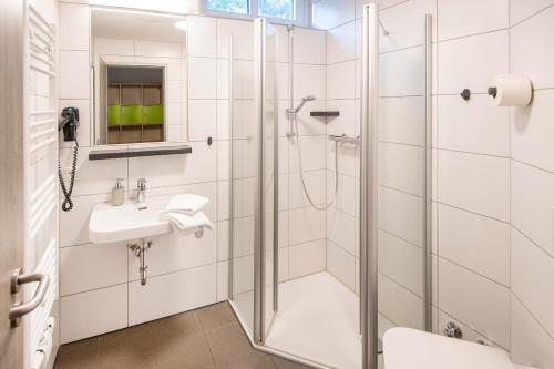 uma casa de banho com um chuveiro e um lavatório. em Hössensportzentrum em Westerstede