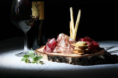 a plate of meat and cheese next to a glass of wine at Hotel Funivia in Bormio