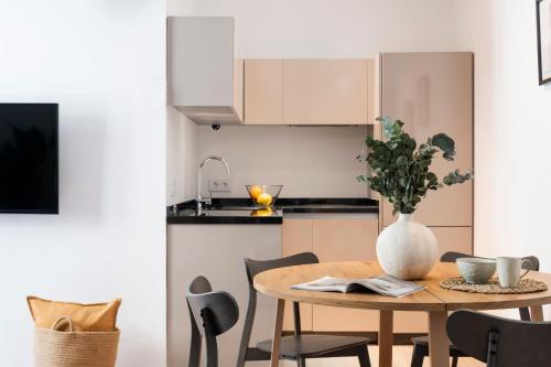 a kitchen with a wooden table with a vase on it at Suites Maestranza - Santas Patronas by Magno Apartments in Seville