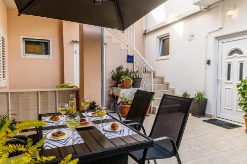 a table and chairs on a patio with an umbrella at Apartments Imperijal Dubrovnik in Dubrovnik