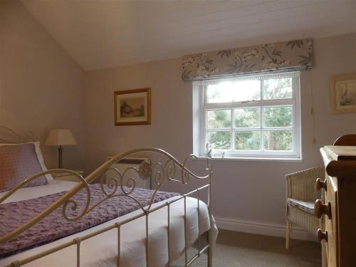 a bedroom with a bed and a window at Pant Glas in Penmaen-mawr