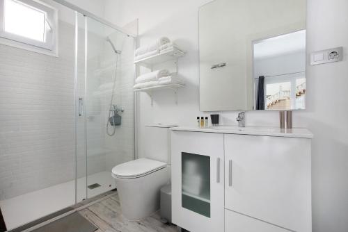 biała łazienka z toaletą i prysznicem w obiekcie La Corte A1 w mieście Antigua