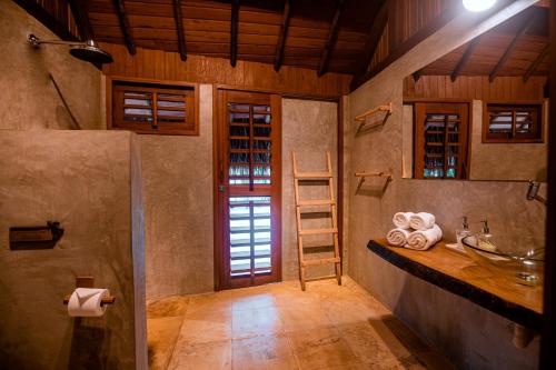 een badkamer met een wastafel en een aanrecht met handdoeken bij La Cozinha Bungalow in Barra Grande