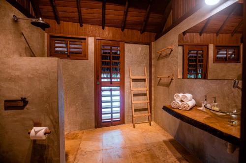 a bathroom with a sink and a counter with towels at La Cozinha Bungalow in Barra Grande