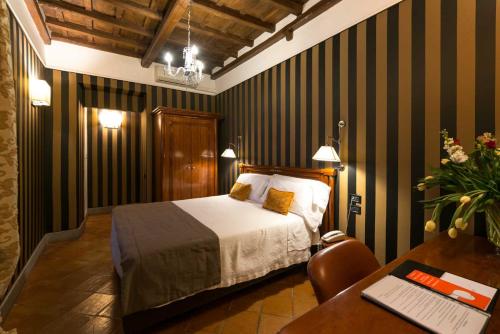 a bedroom with a bed and a desk with a laptop at Duca d'Alba Hotel - Chateaux & Hotels Collection in Rome