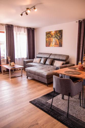 ein Wohnzimmer mit einem Sofa und einem Tisch in der Unterkunft Viktoria‘s Ferienwohnung in Bad Harzburg