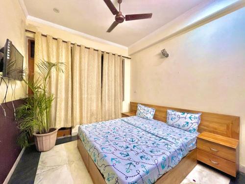a bedroom with a bed and a ceiling fan at Entire floor 2BHK with full Kitchen Near Medanta hospital in Gurgaon