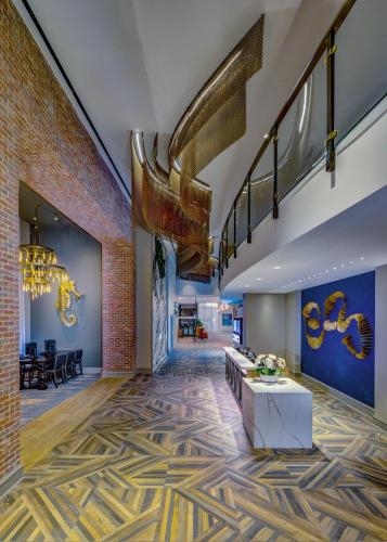a lobby with a staircase and a living room at Embassy Suites By Hilton Virginia Beach Oceanfront Resort in Virginia Beach
