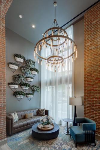 a living room with a couch and a chandelier at Embassy Suites By Hilton Virginia Beach Oceanfront Resort in Virginia Beach