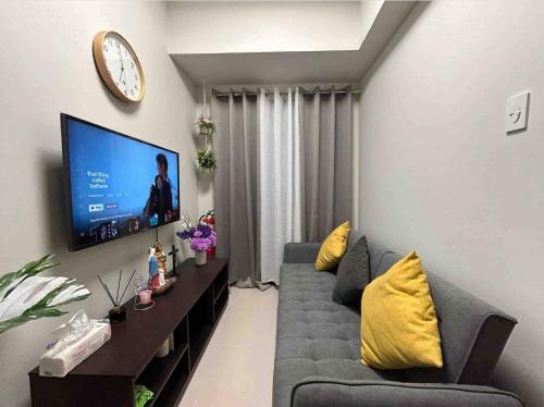 un soggiorno con divano e TV a schermo piatto di The Estrella Suite at the Mall of Asia Complex a Manila