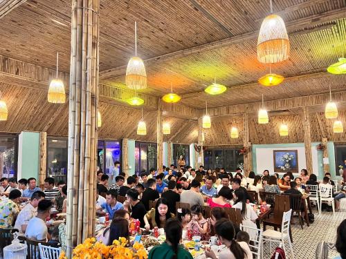 a large group of people sitting at tables in a room at Minh Chau Beach Resort in Quang Ninh