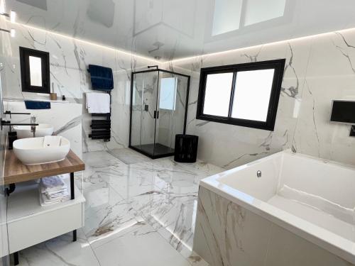 uma casa de banho branca com uma banheira e um lavatório em Villa Folie em Roquebrune-Cap-Martin