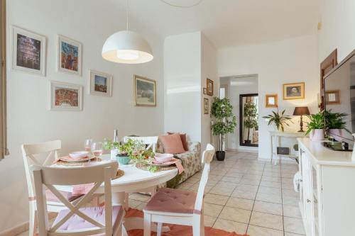 a dining room and living room with a table and chairs at San Leonardo apartment in Lucca