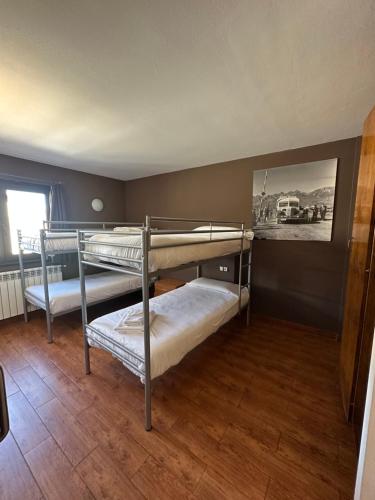 two bunk beds in a room with wood floors at Apartaments ENGAIT in Pas de la Casa