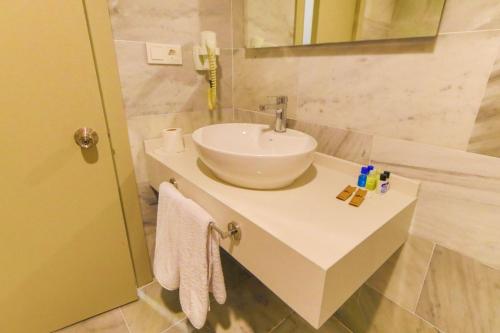 a bathroom with a white sink and a mirror at Ephesus Hitit Hotel restaurant in Selçuk
