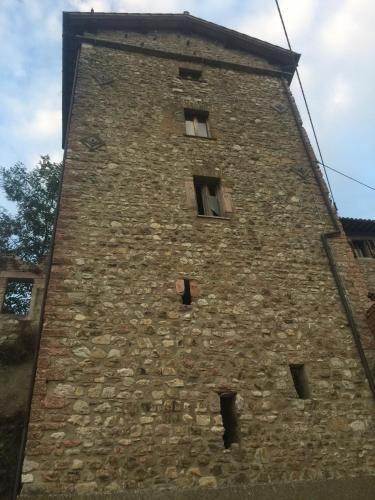 a tall brick tower with windows on a building at Il borgo di Firenzuola Camere con camino in Acquasparta