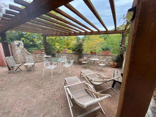 a patio with chairs and tables and a wooden pergola at Il borgo di Firenzuola Camere con camino in Acquasparta