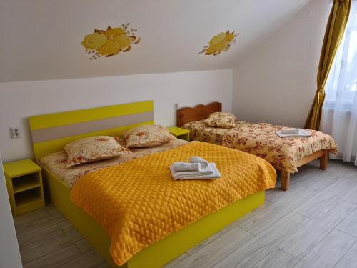a bedroom with two beds with towels on them at Pensiunea Constanta in Bran