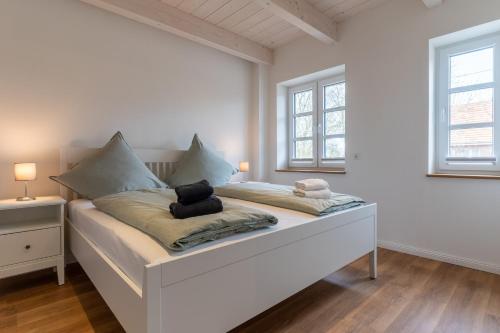 a white bedroom with a bed with a teddy bear on it at DHH Buhne in Karolinenkoog