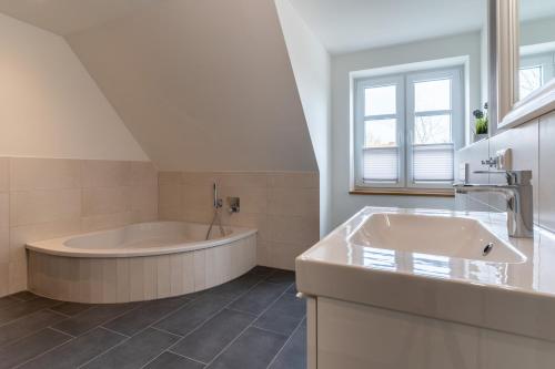 a large bathroom with a tub and a sink at DHH Buhne in Karolinenkoog