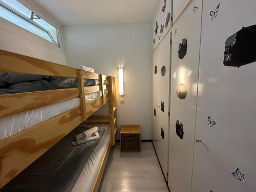 ブラウンラーゲにあるApp 587 mit Schwimmbad und Sauna im Panoramic Hohegeiß Braunlageの二段ベッド2台と廊下が備わる客室です。